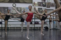 In this photo taken Nov. 25, 2012, Filipino slum dweller Jessa Balote, center, practices with other students during a class at Ballet Manila in the Philippine capital. Balote, who used to tag along with her family as they collect garbage at a nearby dumpsite, is a scholar at Ballet Manila's dance program. As an apprentice, she makes around 7,000 pesos ($170) a month, sometimes double that, from stipend and performance fees. (AP Photo/Aaron Favila)