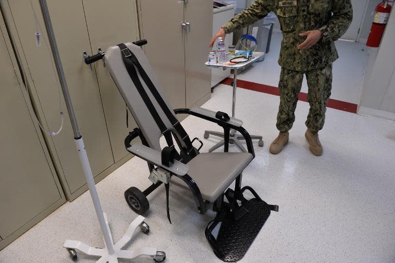 This photo reviewed by the US military and made during an escorted visit shows a US naval medic explaining the "feeding chair" procedures at the detention facility in Guantanamo Bay, Cuba, April 9, 2014