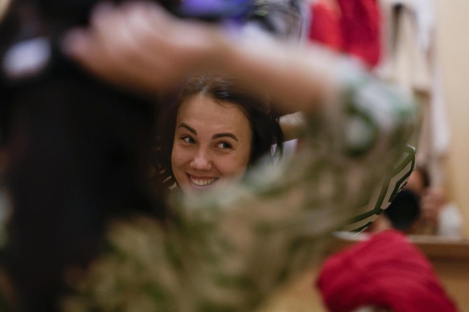 Yuliia Palaida, who pays Alice, combs her hair before the show "Alice in Wonderland" in Pistoia, Italy, Friday, May 6, 2022. A Ukrainian circus troupe is performing a never-ending “Alice in Wonderland” tour of Italy. They are caught in the real-world rabbit hole of having to create joyful performances on stage while their families at home are living through war. The tour of the Theatre Circus Elysium of Kyiv was originally scheduled to end in mid-March. (AP Photo/Alessandra Tarantino)