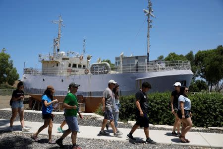 Tourists walk past an original ship used to illegally bring Jewish immigrants, at the former British detention camp of Atlit, currently operated as a museum by the Council for Conservation of Heritage Sites in Israel, June 19, 2018. Picture taken June 19, 2018. REUTERS/Amir Cohen