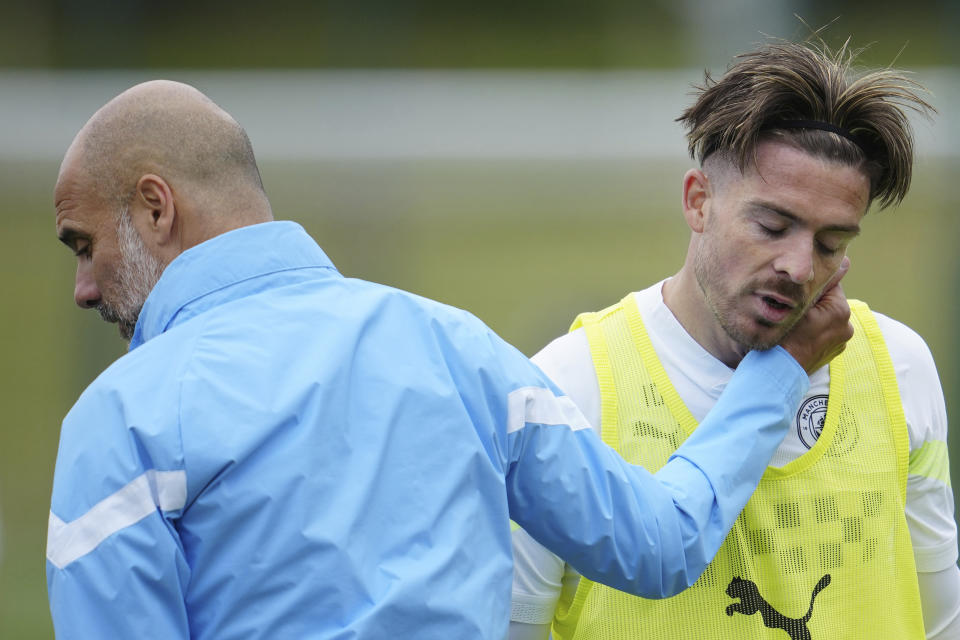 Manchester City's head coach Pep Guardiola, left, embraces Jack Grealish at a UEFA Champions League Media Day before the forthcoming Champion's League final, Manchester, England, Tuesday, June 6, 2023. Manchester City will play Inter Milan in the final of the Champion's League on Saturday June 10 in Istanbul. (AP Photo/Jon Super)