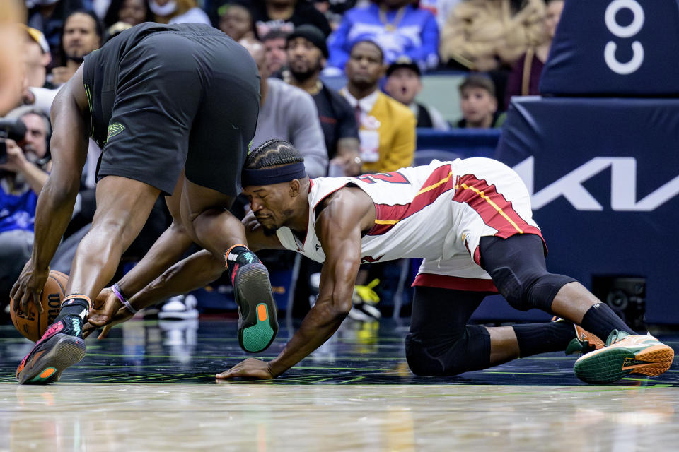 New Orleans Pelicans forward Zion Williamson, left, steals the ball from Miami Heat forward Jimmy Butler, right, during the second half of an NBA basketball game in New Orleans, Friday, Feb. 23, 2024. (AP Photo/Matthew Hinton)
