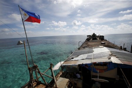 A Philippine flag flutters from BRP Sierra Madre, a dilapidated Philippine Navy ship that has been aground since 1999 and became a Philippine military detachment on the disputed Second Thomas Shoal, part of the Spratly Islands, in the South China Sea March 29, 2014. Picture taken March 29, 2014.  REUTERS/Erik De Castro