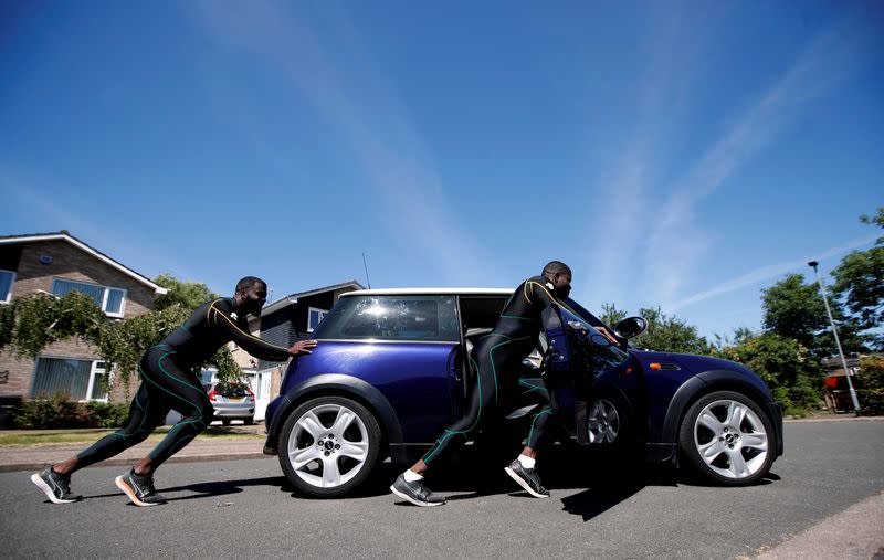 Los miembros del equipo de Bobsleigh de Jamaica Shanwayne Stephens y Nimroy Turgott empujan un Mini Cooper. Han estado empujando el automóvil por las calles de Peterborough como parte de su entrenamiento luego del brote de la enfermedad por coronavirus (COVID-19), Peterborough, Gran Bretaña