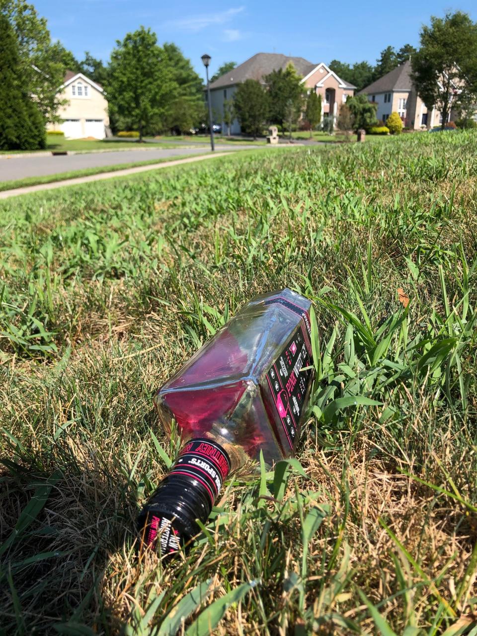 A liquor bottle in the grass in the neighborhood where a large party was held in Jackson, New Jersey, Sunday night.