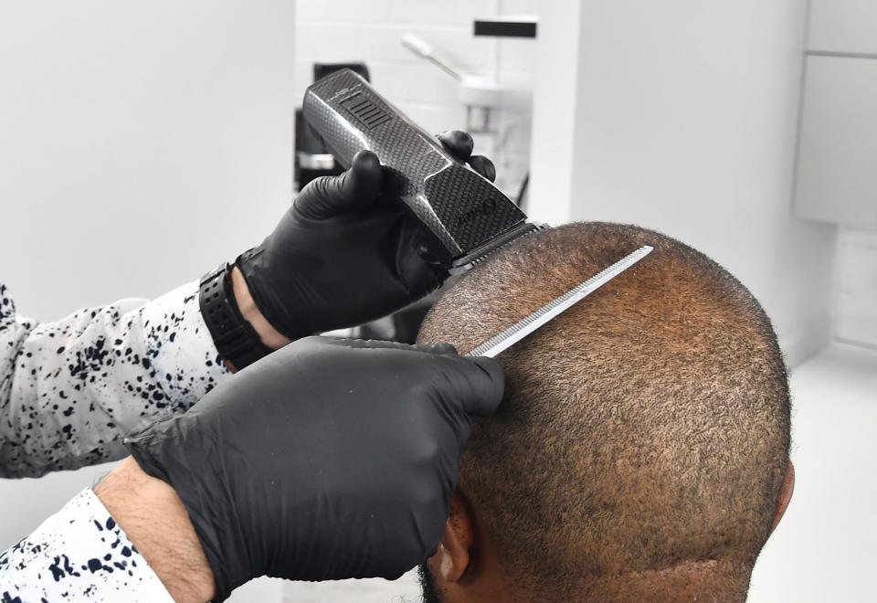 ATLANTA, GEORGIA - MAY 15: Barber Samuel Glickman cuts a client's hair at Privado Grooming Barbershop on May 15, 2020 in Atlanta, Georgia. Georgia Governor Brian Kemp announced that certain businesses including: hair salons, bowling alleys, barbershops and nail salons could reopen on April 24, 2020. There are currently over 36,000 confirmed COVID-19 cases in Georgia.