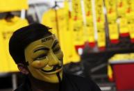 A shopkeeper wearing a pro-democracy group "Bersih" (Clean) mask tends a stall at the Kuala Lumpur and Selangor Chinese Assembly Hall in Malaysia's capital city of Kuala Lumpur August 29, 2015. REUTERS/Edgar Su