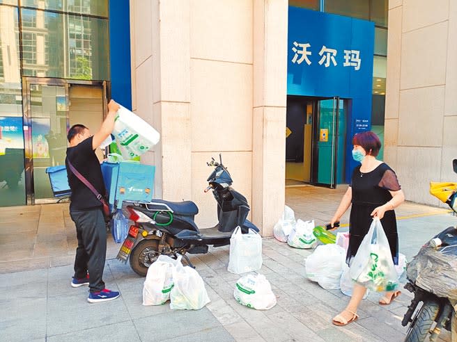 北京疫情再起，民眾開始囤物資，超市門口十多袋網路下單的物資，等著外送員宅配到家。（陳君碩攝）