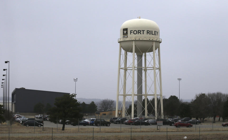 FILE - In this Feb. 9 2015 file photo, vehicles park around a water tower at Fort Riley, Kan. Prosecutors say a U.S. Army soldier shared bomb-making instructions online and also discussed killing activists and bombing a news network. (AP Photo/Orlin Wagner, File)