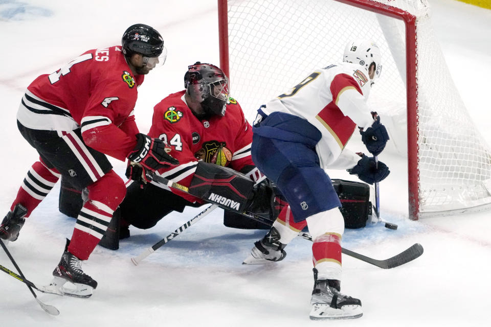 Florida Panthers' Matthew Tkachuk scores past Chicago Blackhawks' Petr Mrazek and Seth Jones during the third period of an NHL hockey game Saturday, Nov. 4, 2023, in Chicago. (AP Photo/Charles Rex Arbogast)