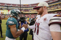 Philadelphia Eagles quarterback Jalen Hurts (1) and Washington Commanders quarterback Carson Wentz (11) greet one another at the end of an NFL football game, Sunday, Sept. 25, 2022, in Landover, Md. Eagles won 24-8. (AP Photo/Alex Brandon)