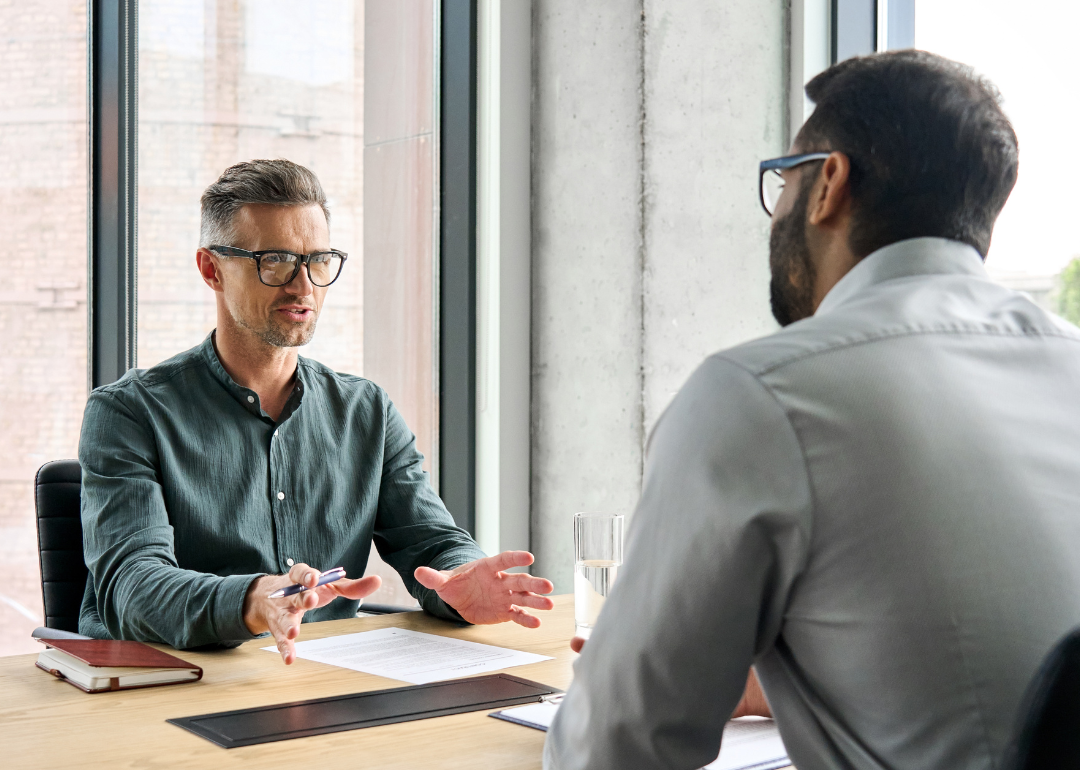 Two men at a table in conversation.