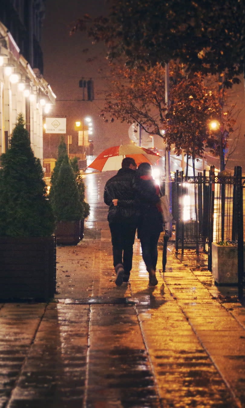 couple walking in rain with umbrella