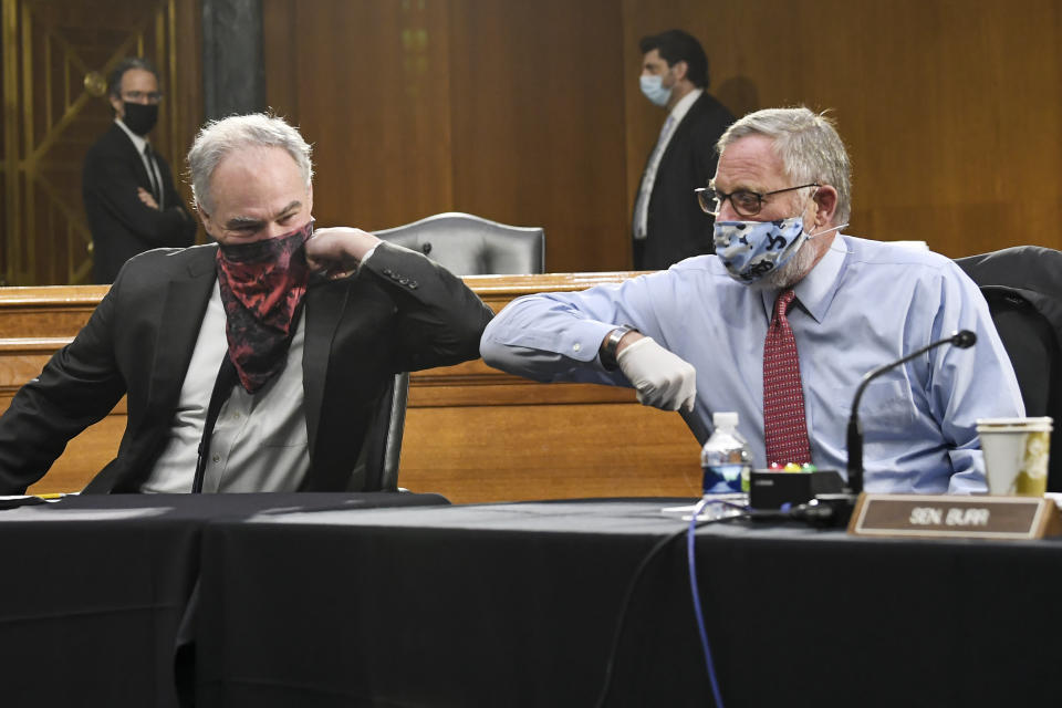 Sen. Tim Kaine, D-Va., left, and Sen. Richard Burr, R-N.C., greet each other with an elbow bump before the Senate Committee for Health, Education, Labor, and Pensions hearing, Tuesday, May 12, 2020 on Capitol Hill in Washington. Dr. Anthony Fauci, director of the National Institute of Allergy and Infectious Diseases, is to testify before the committee. (Toni L. Sandys/The Washington Post via AP, Pool)