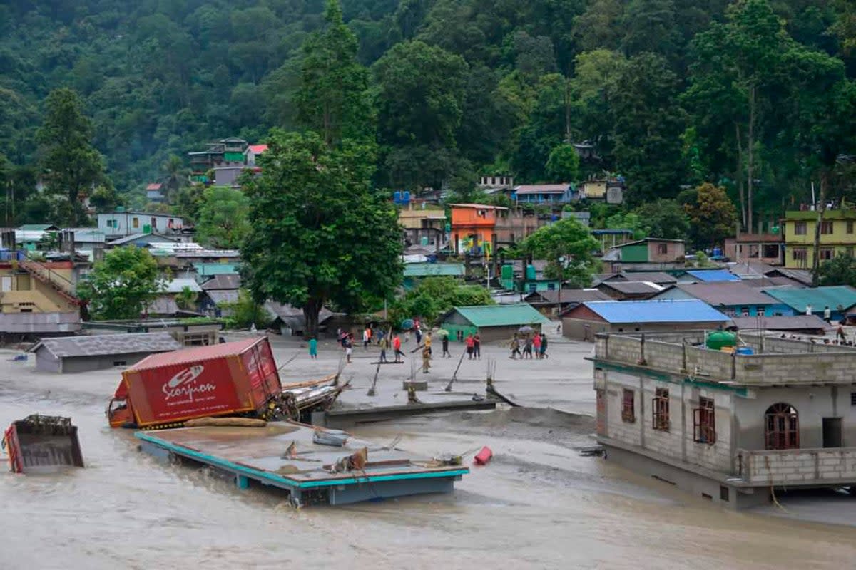 A vehicle that got washed away lies atop a submerged building after flash floods triggered by a sudden heavy rainfall swamped the Rangpo town in Sikkim, India, Thursday, 5 October 2023 (AP)
