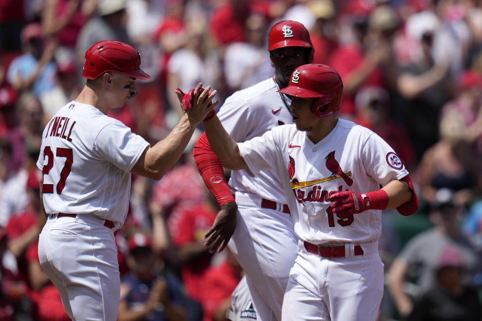 St. Louis Cardinals' Tommy Edman (19) is congratulated by teammates Tyler O'Neill (27) and Jordan Walker after hitting a three-run home run during the third inning of a baseball game against the Arizona Diamondbacks Wednesday, April 19, 2023, in St. Louis. (AP Photo/Jeff Roberson)