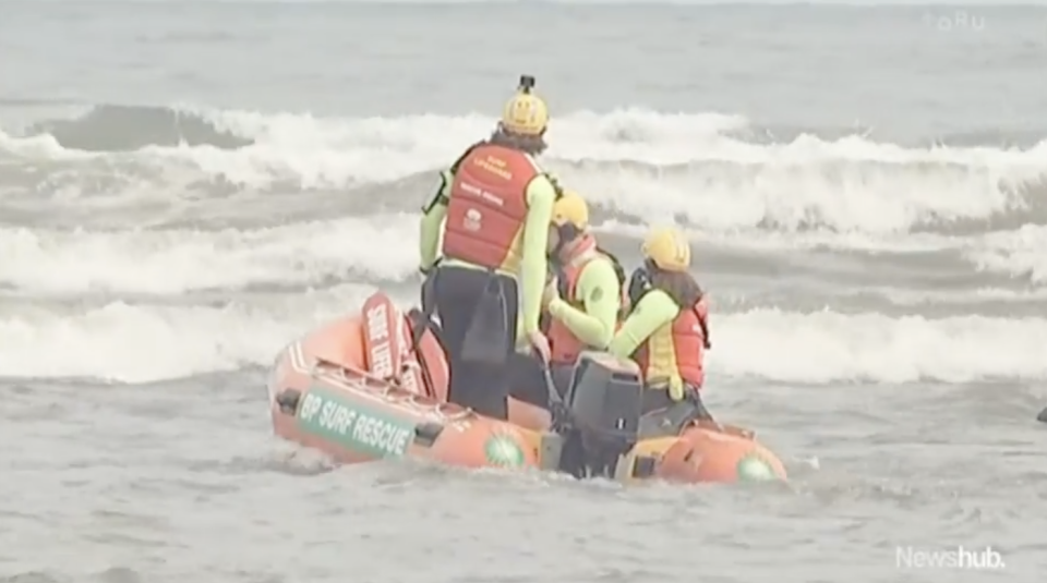 Rescuers search New Zealand's Kiritehere Beach for the missing Phillips family.