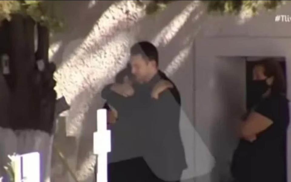 Babis Anagnostopoulos hugs his grieving mother-in-law at his wife's memorial service, just hours before he admitting to her murder