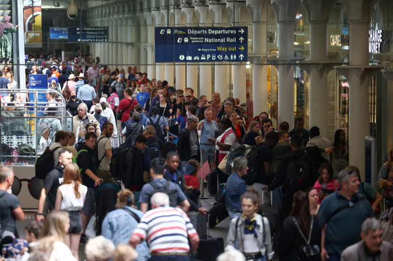 FILE PHOTO: People queue to check in for the Eurostar rail service at St Pancras International Station in London