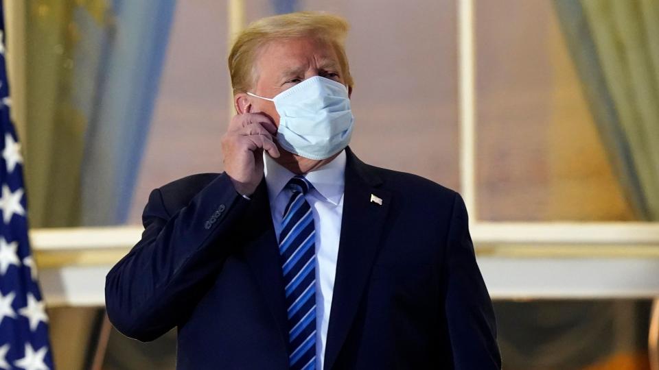 Mandatory Credit: Photo by Alex Brandon/AP/Shutterstock (10911987r)President Donald Trump removes his mask as he stands on the balcony outside of the Blue Room as returns to the White House, in Washington, after leaving Walter Reed National Military Medical Center, in Bethesda, Md.