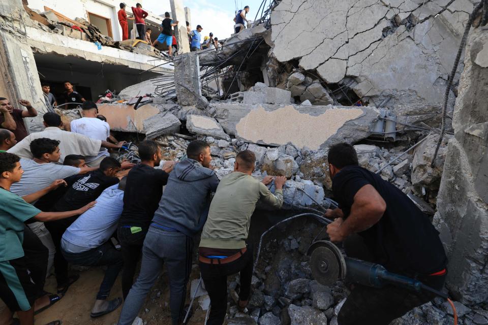 Palestinians search through the rubble of a building after an Israeli strike in Khan Yunis in the southern Gaza Strip.