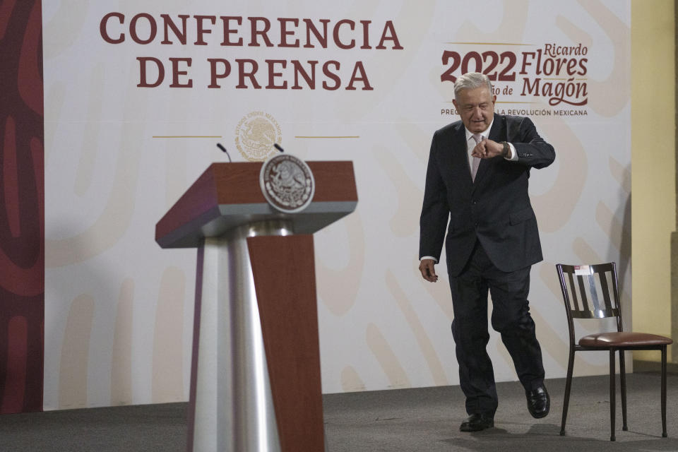 Mexican President Andres Manuel Lopez Obrador looks at his watch as he arrives to give his daily press conference at the National Palace in Mexico City, Friday, July 8, 2022. (AP Photo/Moises Castillo)