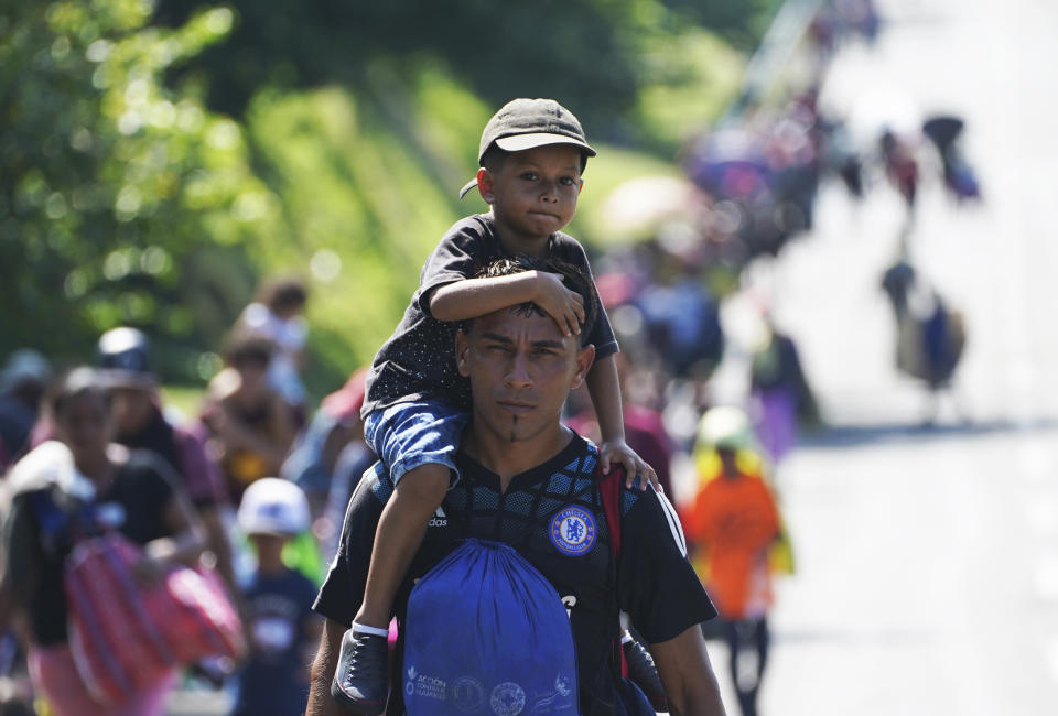 A child sits on the shoulders of a migrant man as they arrive in Villa Comaltitlan, Chiapas state, Mexico, Wednesday, Oct. 27, 2021, on their journey through Mexico to the U.S. border. (AP Photo/Marco Ugarte)