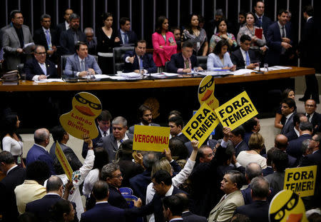 Opposition members of the lower chamber of Brazil's Congress protest before a vote on whether the Congress allows charges against President Michel Temer to be sent to the Supreme Court for trial, in Brasilia, Brazil October 25, 2017. The placards read: "Shame" (C) and "Out Temer." REUTERS/Adriano Machado