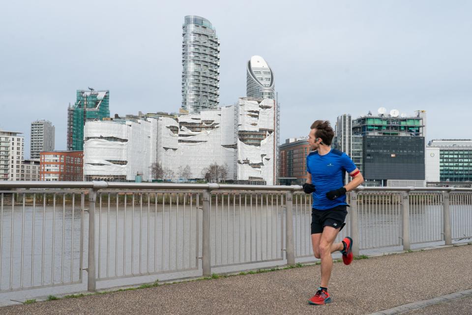 Runner looks at construction site damage on the Thames (PA)