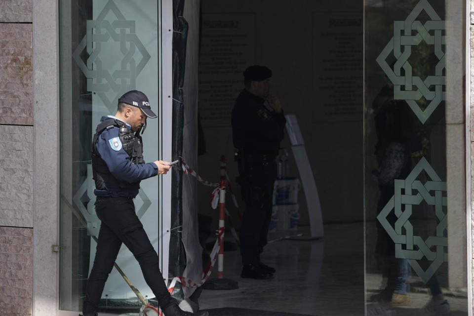 A police officer walks at the entrance of an Ismaili Muslim center in Lisbon, Portugal, Tuesday, March 28, 2023. Portuguese police have shot a man suspected of stabbing two people to death at an Ismaili Muslim center in Lisbon. Authorities said police were called to the center late Tuesday morning where they encountered a suspect armed with a large knife. (AP Photo/Armando Franca)