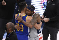 Golden State Warriors guard Stephen Curry, left, and Washington Wizards guard Bradley Beal, right, hug after an NBA basketball game, Wednesday, April 21, 2021, in Washington. The Wizards won 118-114. (AP Photo/Nick Wass)