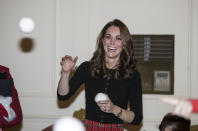 The Duchess of Cambridge enjoys a wintry tradition without the cold as she throws a mock snowball during a children's pretend snowball fight at a Christmas party at Kensington Palace in December 2018. (Richard Pohle - WPA Pool/Getty Images)