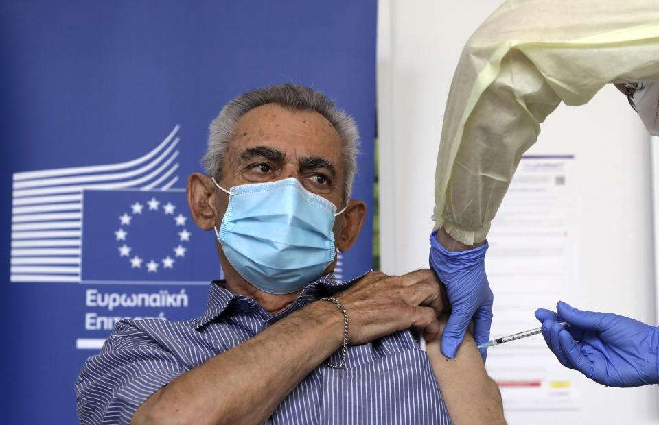 Andreas Raounas, 84, the first patient in Island receives from a nurse the vaccine of Pfizer BioNtech against the COVID-19, at a care home in Nicosia, Cyprus, Sunday, Dec. 27, 2020. Cyprus started today the vaccination program against COVID-19. (Katia Christodoulou/Pool Photo via AP)