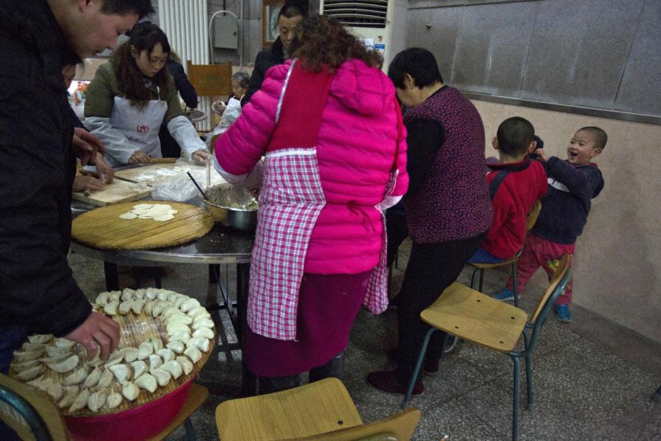 Niños jugando mientras varios aldeanos se reúnen para hacer empanadillas antes del Año Nuevo lunar en un pueblo a las afueras de Beijing, China, el jueves 26 de enero de 2017. (AP Foto/Ng Han Guan)