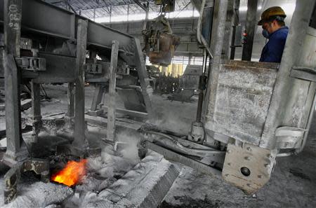 An employee crushes crust on active electrolysis cells in Montenegro's Kombinat Aluminijuma Podgorica (KAP) aluminium factory in Podgorica September 9, 2013. REUTERS/Stevo Vasiljevic