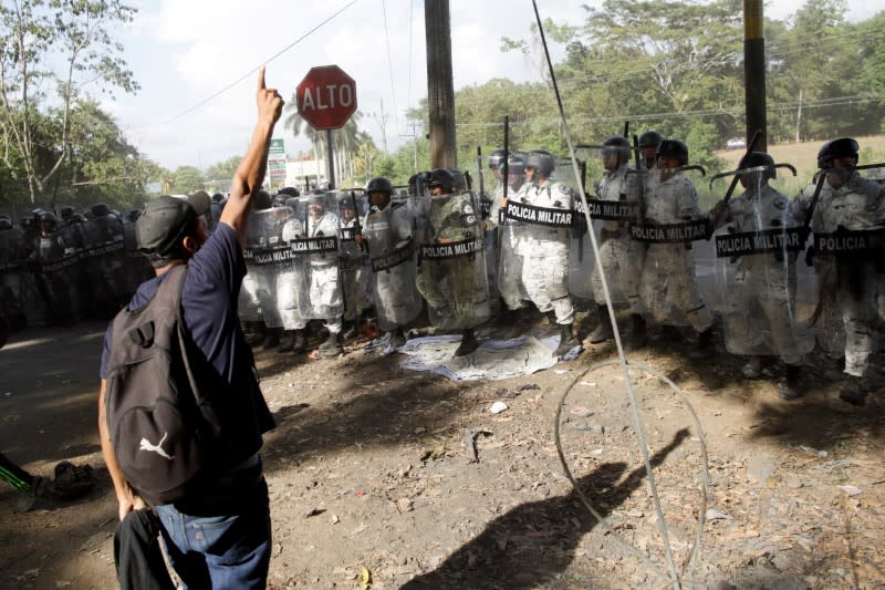 A man gestures as members of the security forces take position, near Frontera Hidalgo, Chiapas