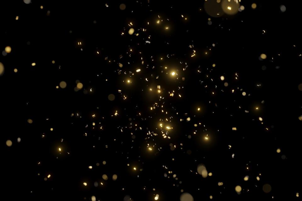 glittering golden confetti on black isolated background christmas and new year concept in trendy festive golden color