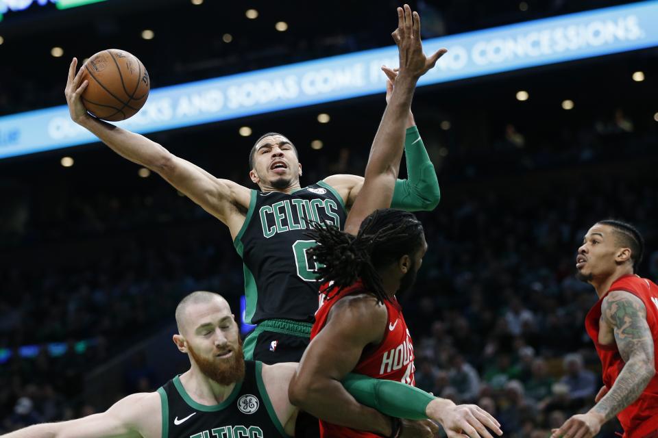 Boston Celtics' Jayson Tatum (0) shoots against Houston Rockets' Nene Hilario, lower right, during the first half of an NBA basketball game in Boston, Sunday, March 3, 2019. (AP Photo/Michael Dwyer)