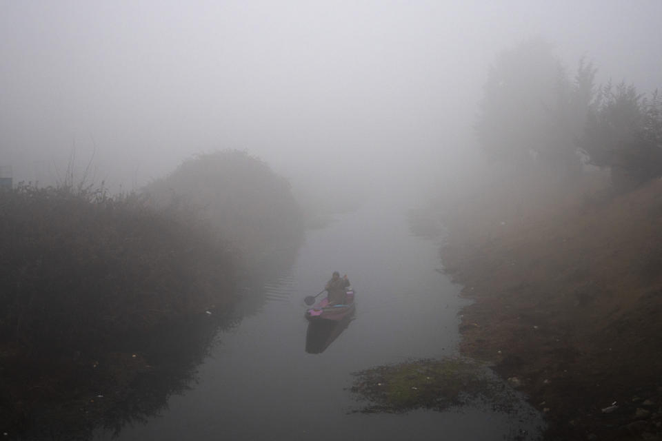 A Kashmiri fisherman rows his boat on the Dal Lake surrounded by a dense fog on a cold morning in Srinagar, Indian controlled Kashmir, Thursday, Dec. 28, 2023. (AP Photo/Dar Yasin)