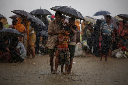 Rohingya refugees try to take shelter from torrential rain as they are held by the Border Guard Bangladesh (BGB) after illegally crossing the border, in Teknaf, Bangladesh, August 31, 2017. REUTERS/Mohammad Ponir Hossain