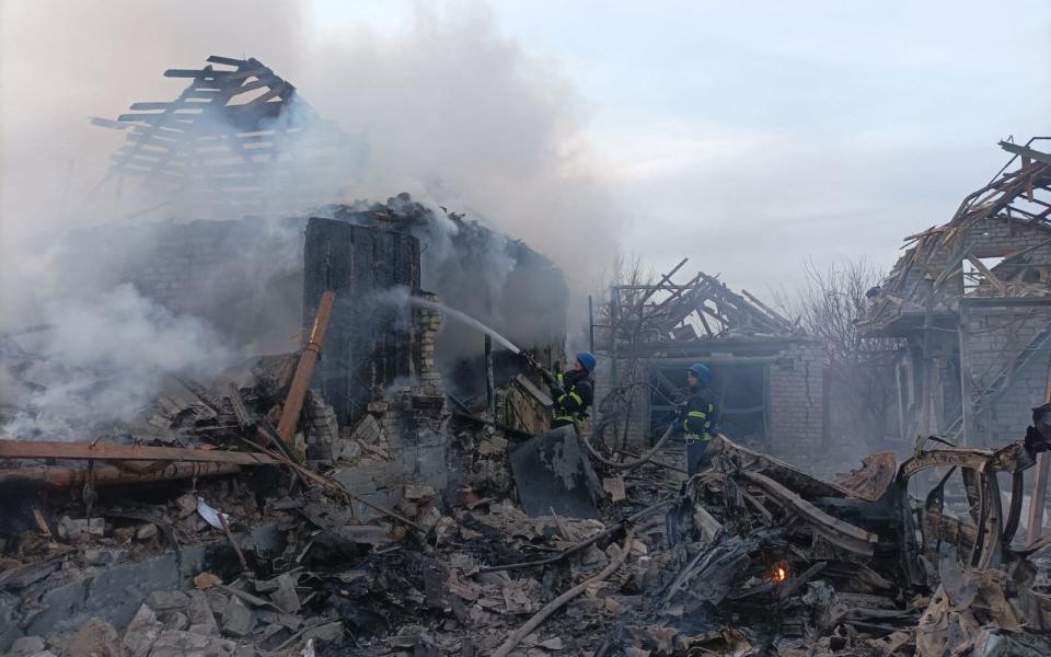 Rescuers pushing out a fire in houses after a strike in Donetsk