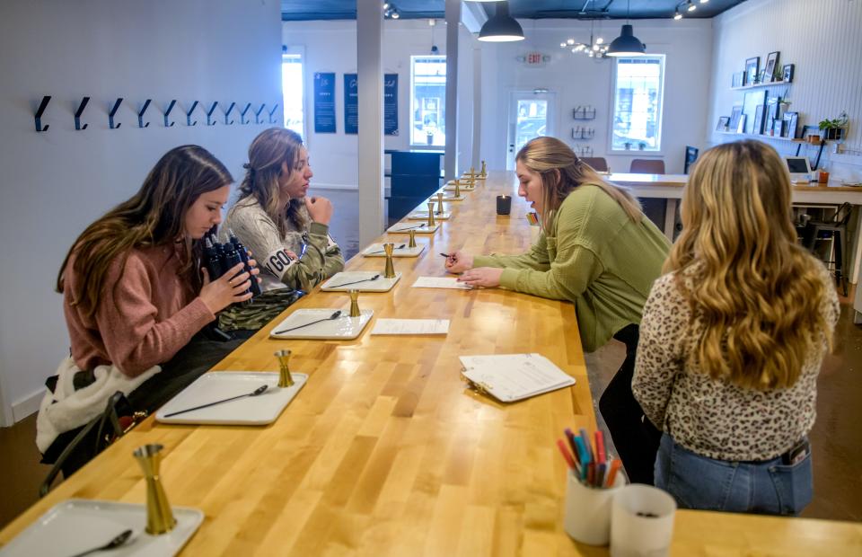 Generations Candle Co. manager Allie Meister, second from right, and employee London Rogers, far right, help customers Morgan Greene, left, and Kassidy Post, both of Eureka, choose their mix of scents for their candles at Generations Candle Co. in Peoria Heights.