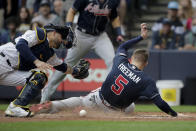 Atlanta Braves' Freddie Freeman scores past Milwaukee Brewers catcher Manny Pina during the third inning of the Game 2 in baseball's National League Divisional Series Saturday, Oct. 9, 2021, in Milwaukee. Freeman on a hit by Ozzie Albies. (AP Photo/Aaron Gash)