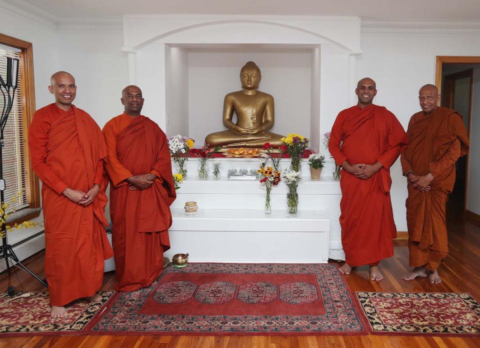 Bhante Kamalasiri, from left, Bhante Sankichcha, Bhante Pemaratana, the head monk of the Cleveland Buddhist Vihara and Meditation Center, and Bhante Shantha stand in the meditation room of the center in Akron.