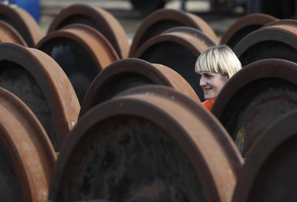 In this Thursday, Oct. 18, 2018 photograph a female worker smiles at a railroad track gauge changer in Chop, Ukraine. A new education law that could practically eliminate the use of Hungarian and other minority languages in schools after the 4th grade is just one of several issues threatening this community of 120,000 people. Many are worried that even as Ukraine strives to bring its laws and practices closer to European Union standards, its policies for minorities seem to be heading in a far more restrictive direction. (AP Photo/Laszlo Balogh)