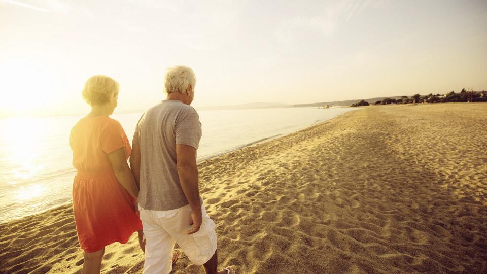 old couple walking on the beach