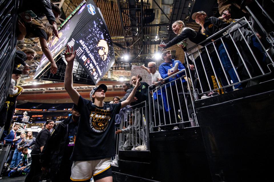 Iowa guard Caitlin Clark celebrates with fans as she exits the court after winning an Elite Eight college basketball game in the NCAA Tournament against Louisville, Sunday, March 26, 2023, in Seattle.