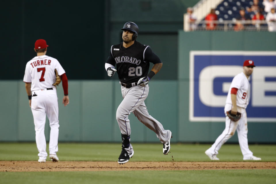 Colorado Rockies' Ian Desmond, center, rounds the bases past Washington Nationals shortstop Trea Turner, left, and second baseman Brian Dozier after hitting a solo home run in the ninth inning of a baseball game, Thursday, July 25, 2019, in Washington. Colorado won 8-7. (AP Photo/Patrick Semansky)