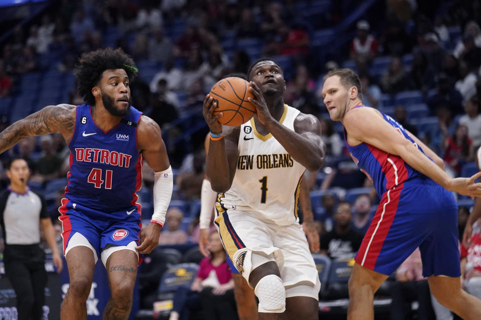 New Orleans Pelicans forward Zion Williamson (1) goes to the basket between Detroit Pistons forward Saddiq Bey (41) and forward Bojan Bogdanovic in the second half of an NBA preseason basketball game in New Orleans, Friday, Oct. 7, 2022. The Pelicans won 107-101. (AP Photo/Gerald Herbert)