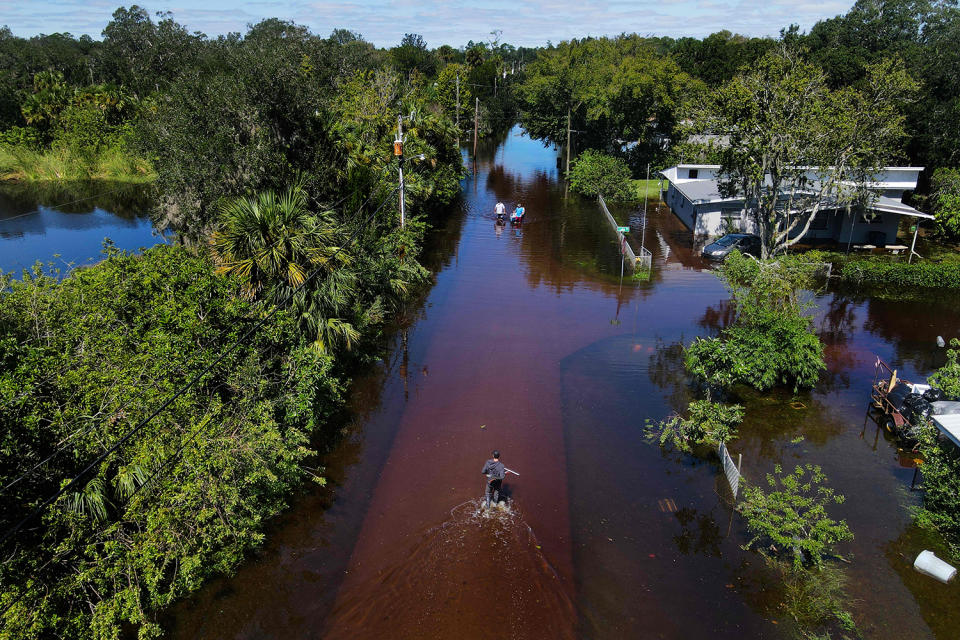 <p>In New Smyrna Beach, Florida, on Sept. 30, people wade through the flooded streets. </p>